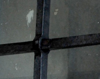 G04 — Détails de grille en trou renflé. Les trous sont à plats et entrecroisés, les deux barreaux du milieu sont emprisonnés par les barreaux des côtés. Cela a nécessité une opération particulière lors de l’assemblage à chaud de cette grille.